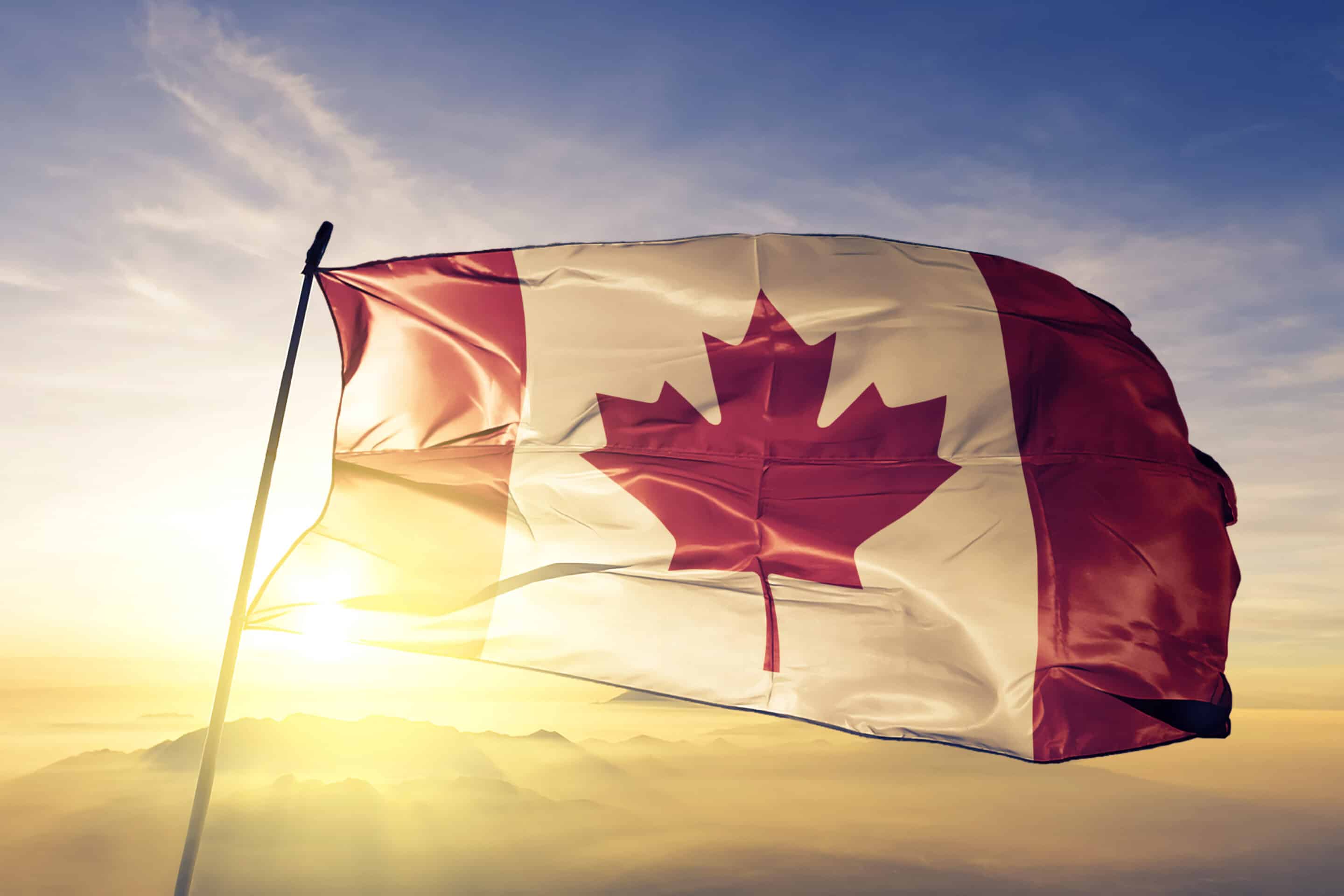 Canada Canadian flag textile cloth fabric waving on the top sunrise mist fog Canada Canadian flag on flagpole textile cloth fabric waving on the top sunrise mist fog